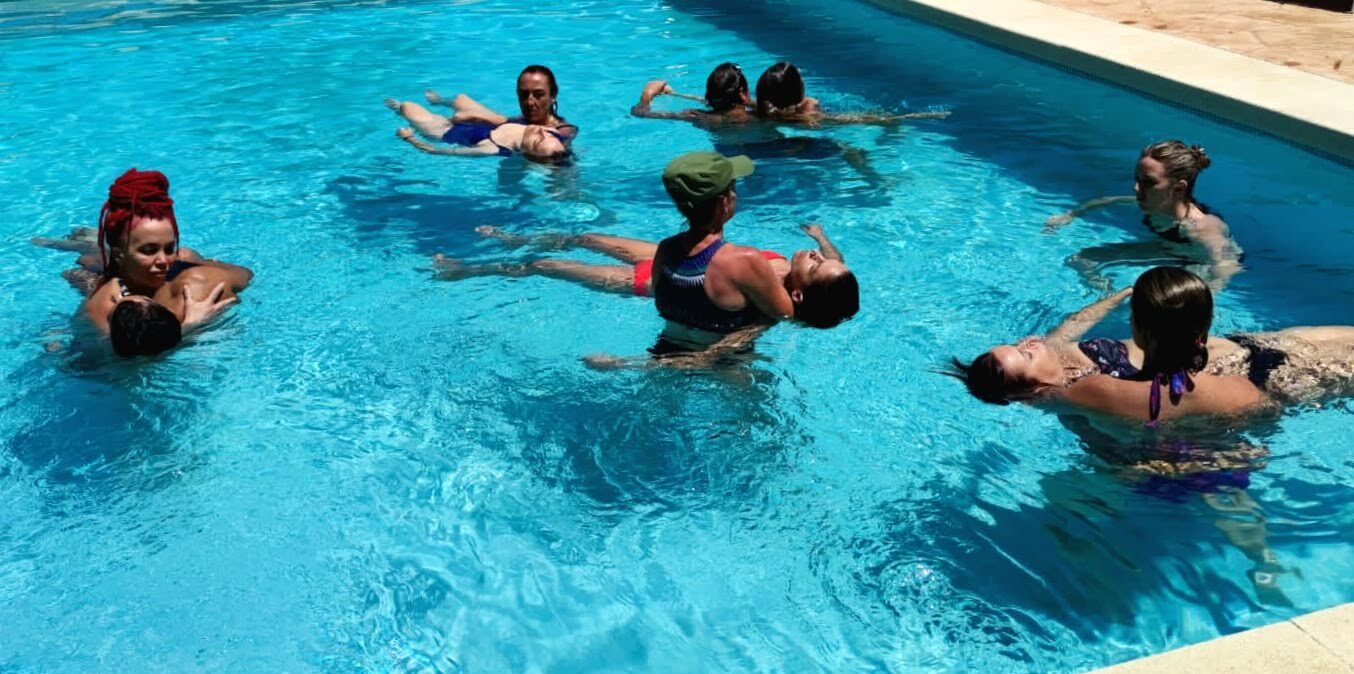 Grupo practicando sostén y flotación en la piscina
